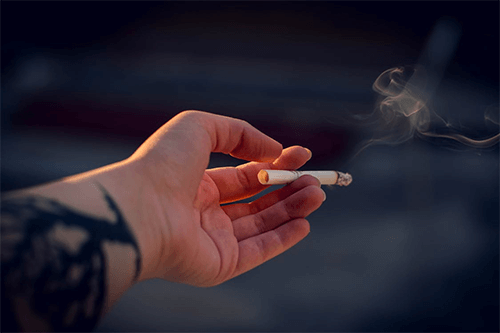 Hand holding a cigarette